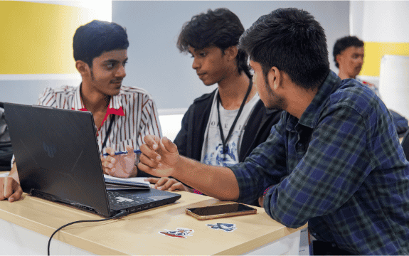 LSA students collaborating around a laptop on a practical project